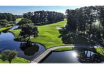 A scenic aerial view of River Hills Golf & Country Club featuring a lush green golf course, water hazards, and surrounding trees in Myrtle Beach, SC.